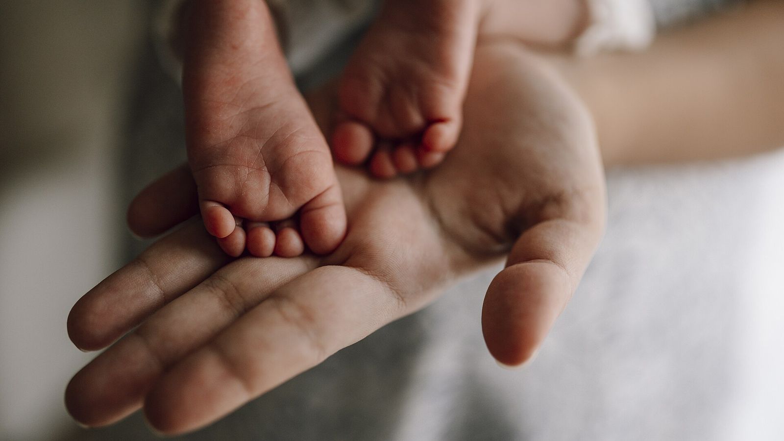 Mãe segurando os pés de um bebê recém-nascido